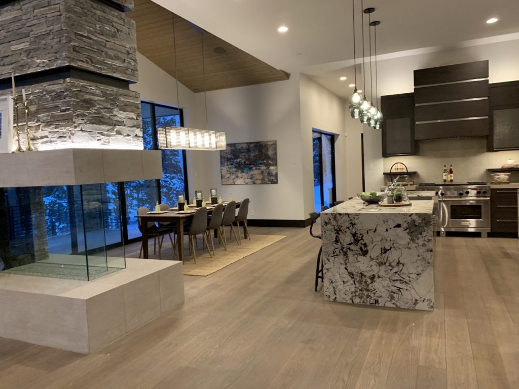 A modern kitchen with a fireplace and a large island, featuring sleek design and ample space for cooking and entertaining.