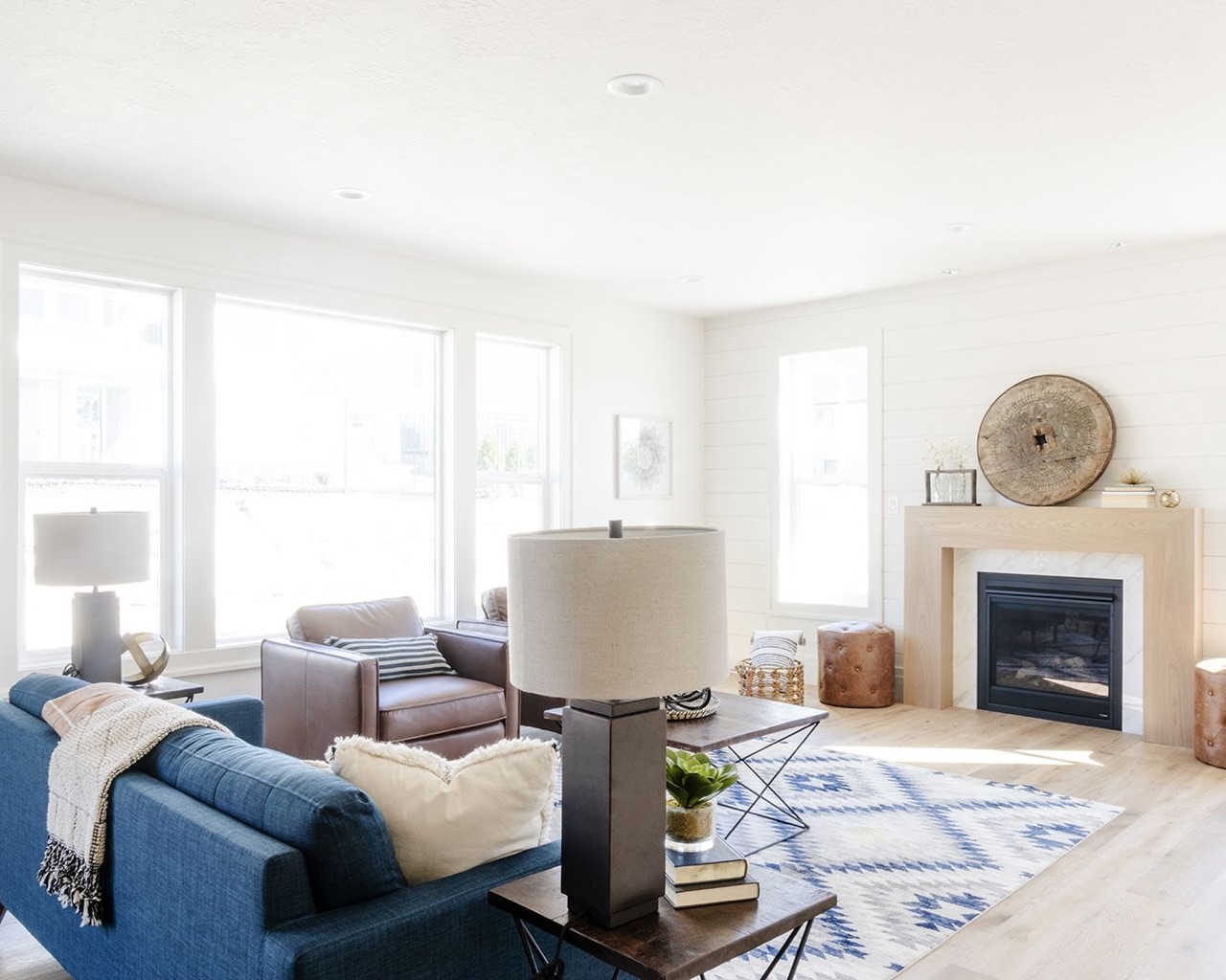 A tidy living room with a blue couch and a fireplace.