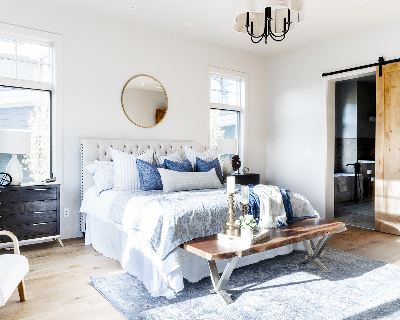 A cozy bedroom with a comfortable bed, a large mirror, and a rustic wooden door.