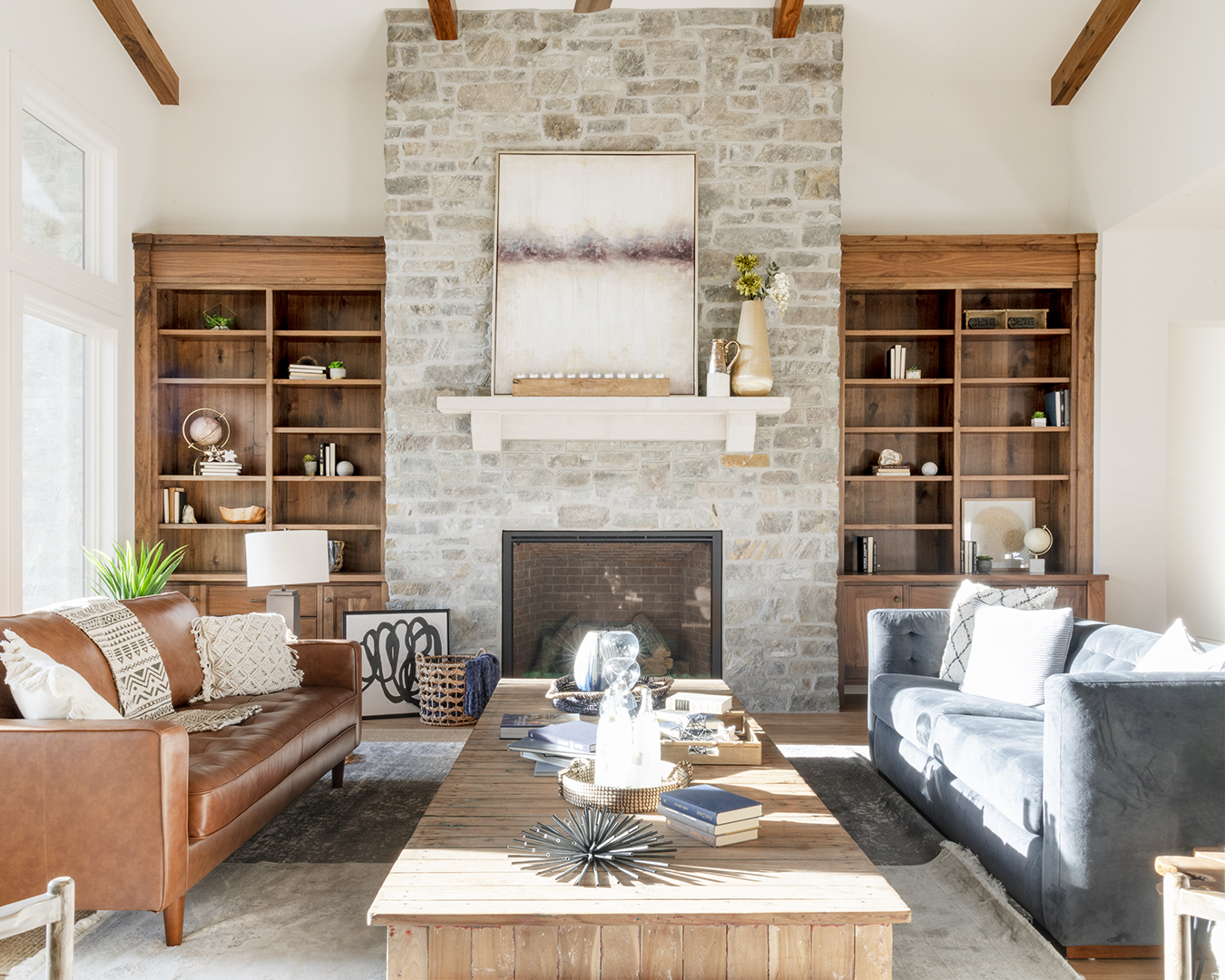 A cozy living room with a stone fireplace and comfortable leather couches.