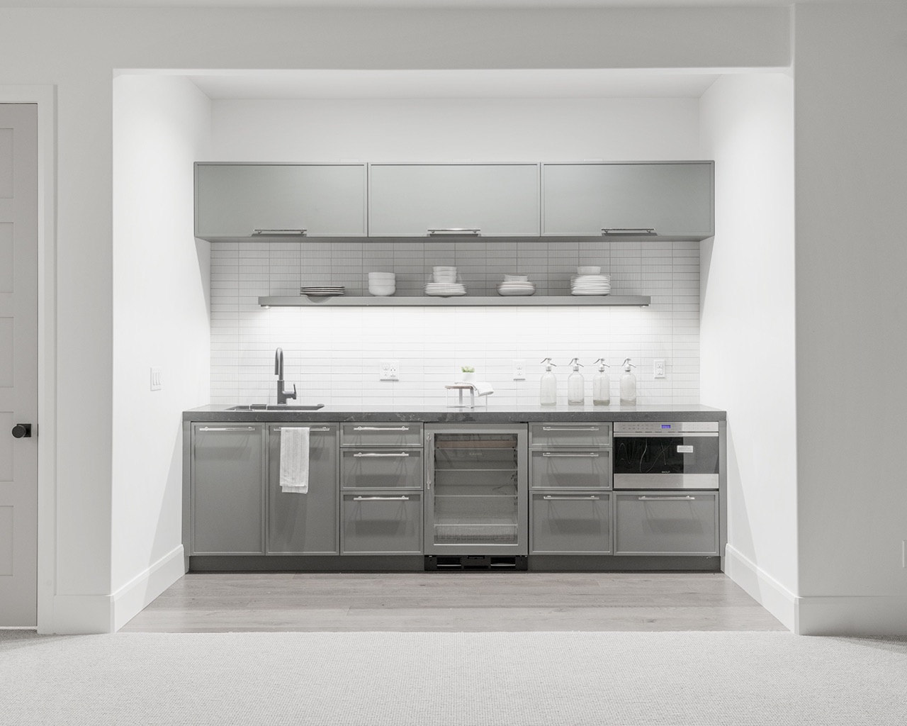 A white kitchen with sink and cabinets.