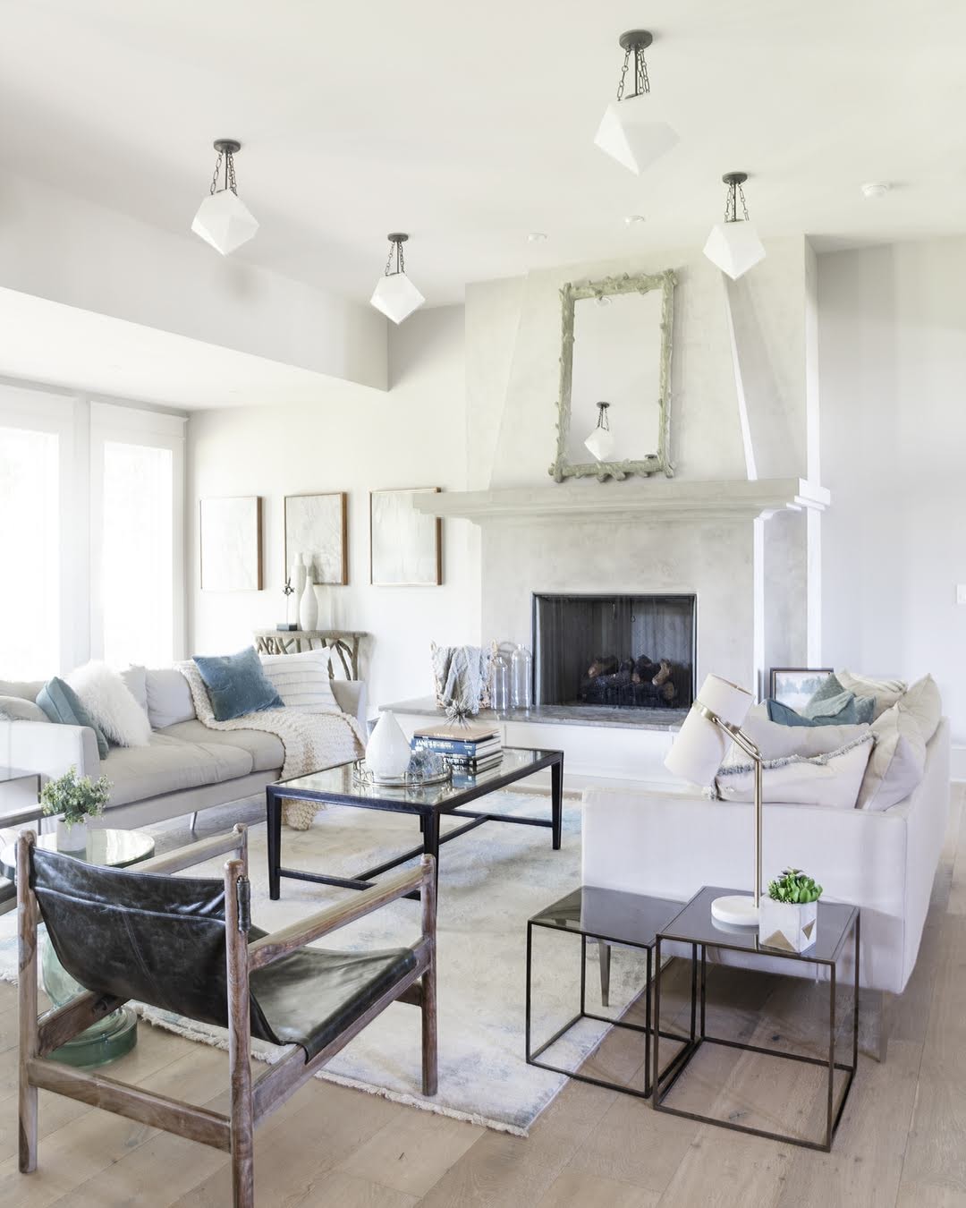 A pristine living room with white furniture and a fireplace, creating a serene and elegant ambiance.