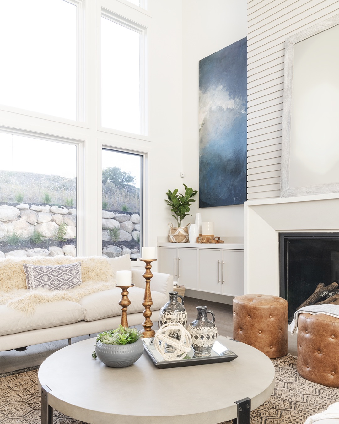 Modern living room with white furnishings and a fireplace.