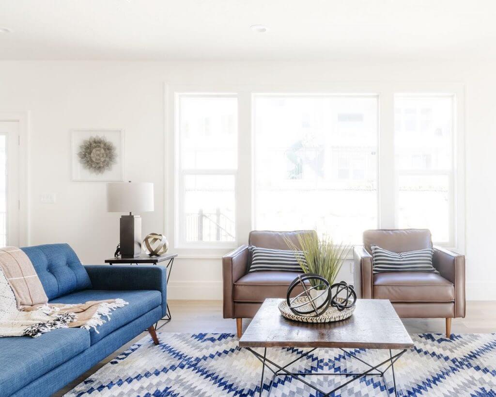 A modern living room featuring a blue couch and chair.