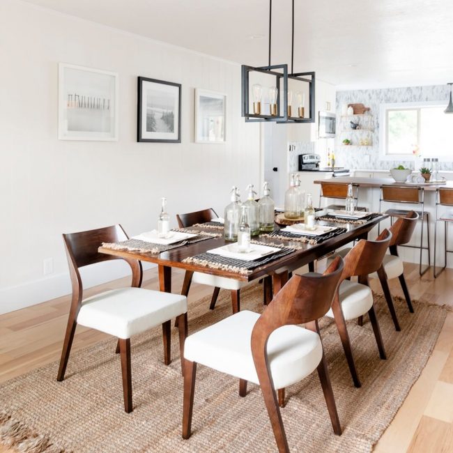 A dining room with white walls and wooden floors.