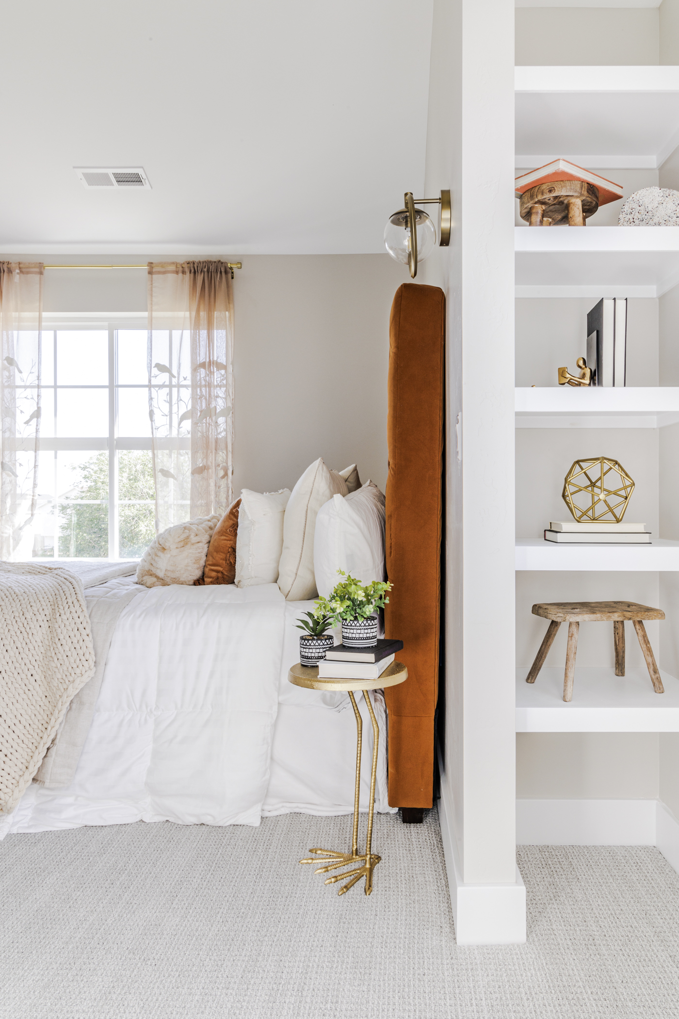 A bedroom with a bed, a bookcase, and a window