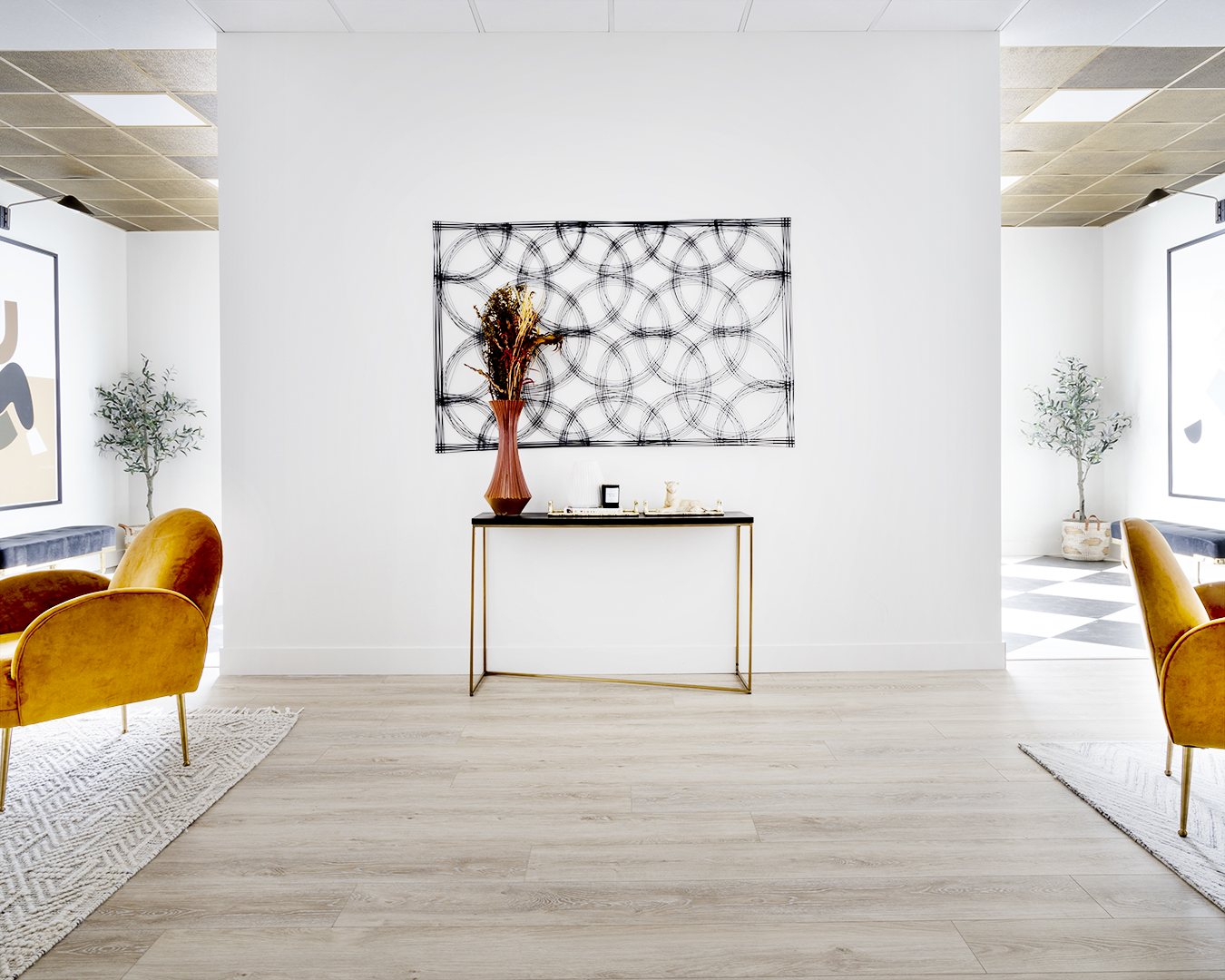 Modern office with wooden floor, featuring two chairs and a table.