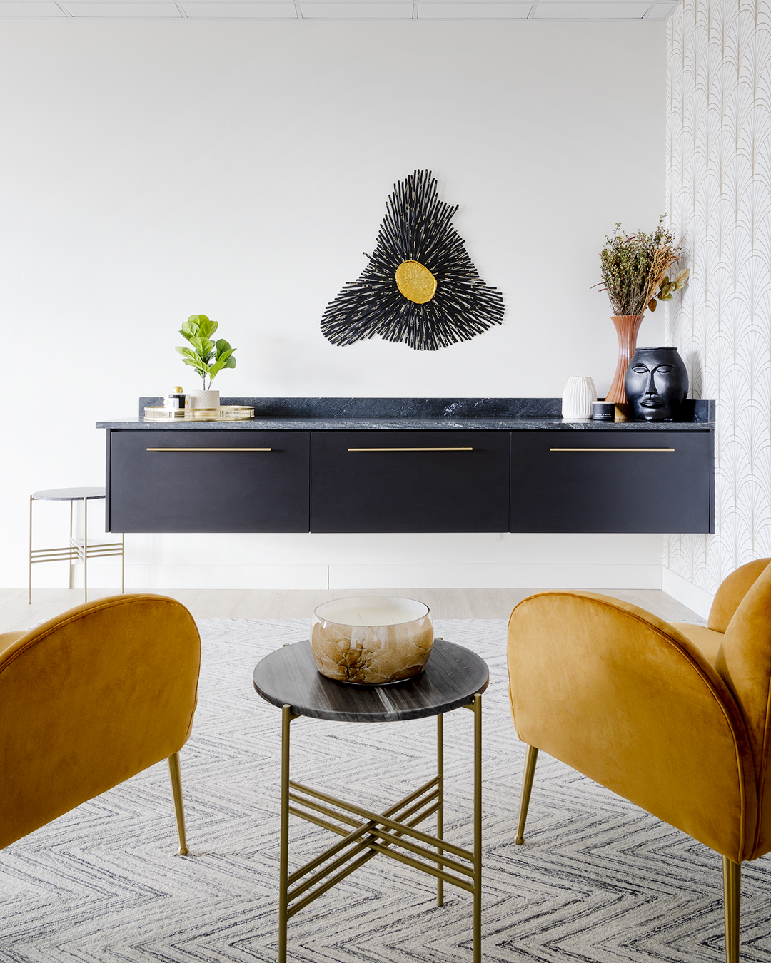 A contemporary office featuring two mustard chairs and a black cabinet.