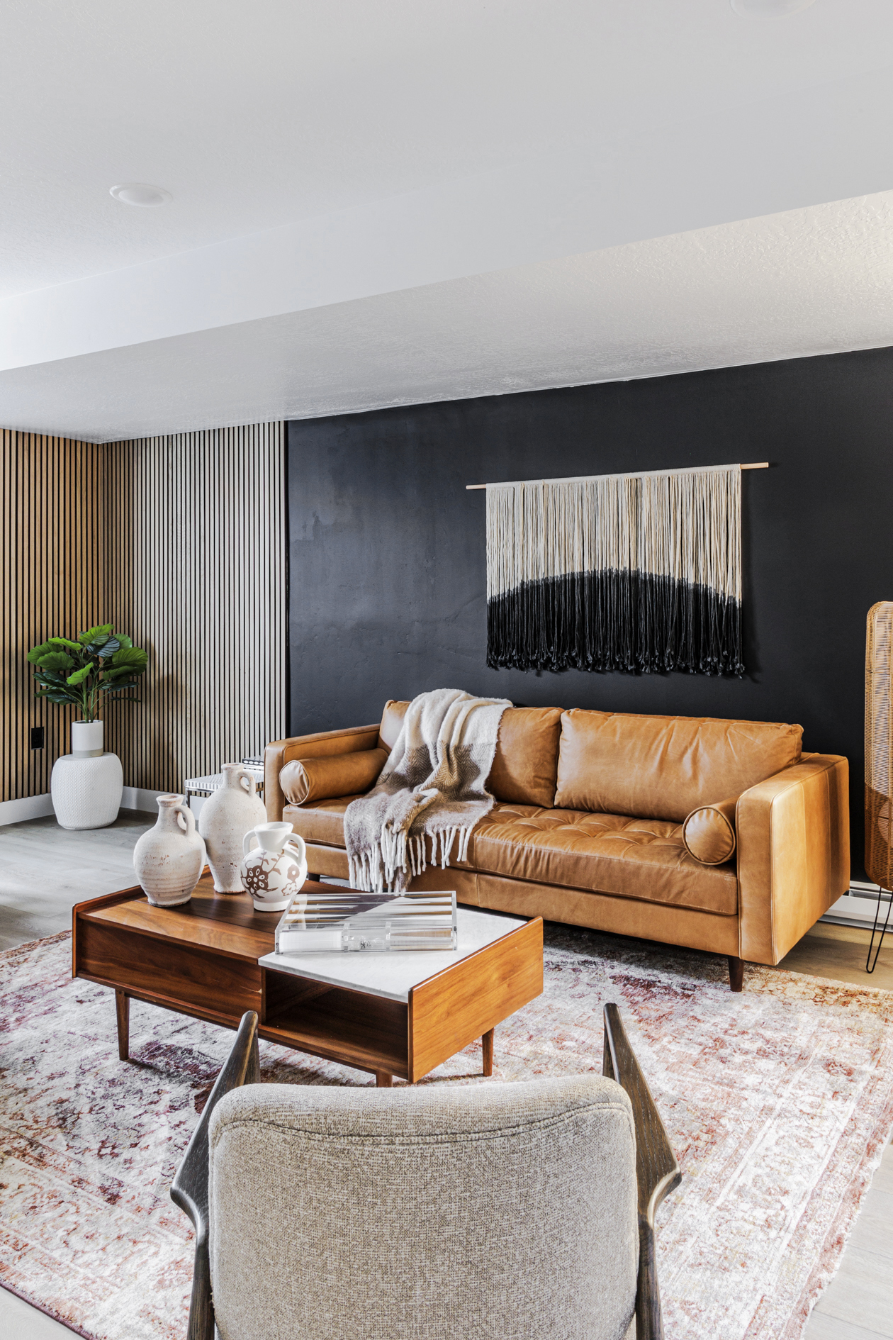 A cozy living room with a leather couch, coffee table, and rug, creating a warm and inviting atmosphere.