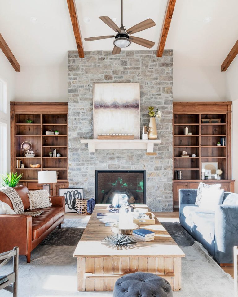 Living room with stone fireplace and leather couches.