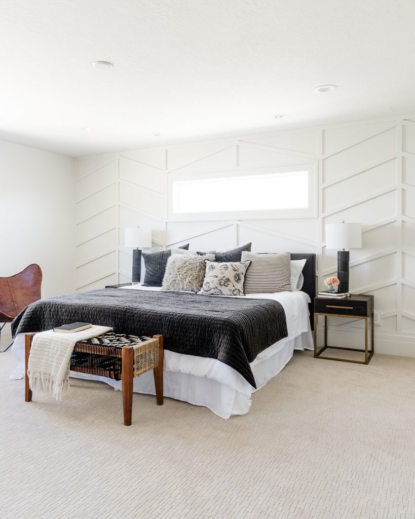 A bedroom with white walls and carpet.