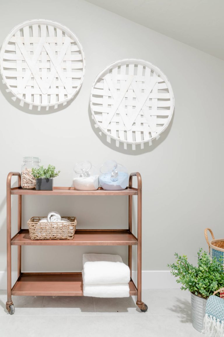 White bathroom featuring white vanity and wooden cart.