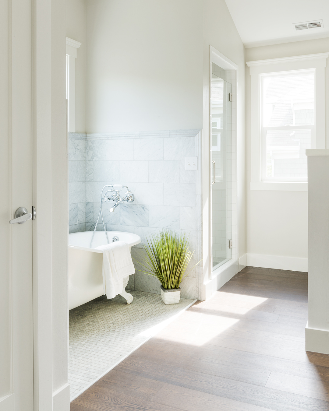 A bathroom with a tub and a window, offering a serene view of the outdoors.