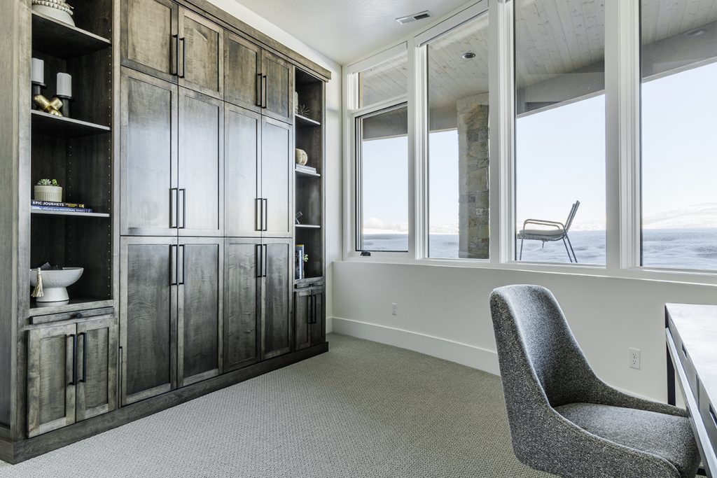 A home office with a desk, window, and cabinet.